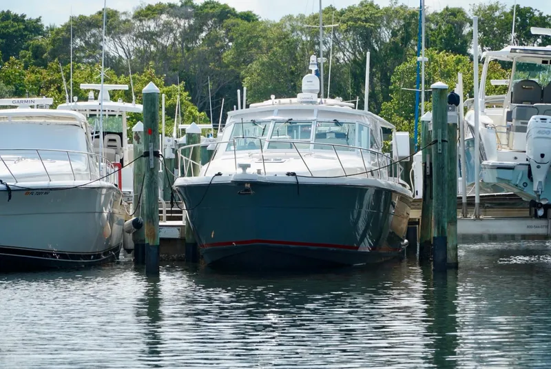 Slide: The Image of 1998 Tiara Yachts 4000 Express docked at a marina, surrounded by other boats. - 11