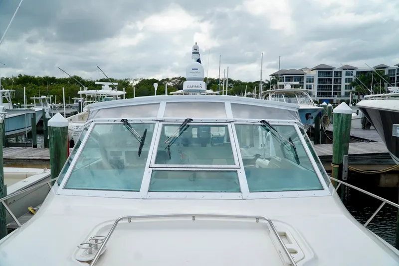 Slide: The Image of 1998 Tiara Yachts 4000 Express docked at marina under cloudy skies. - 13