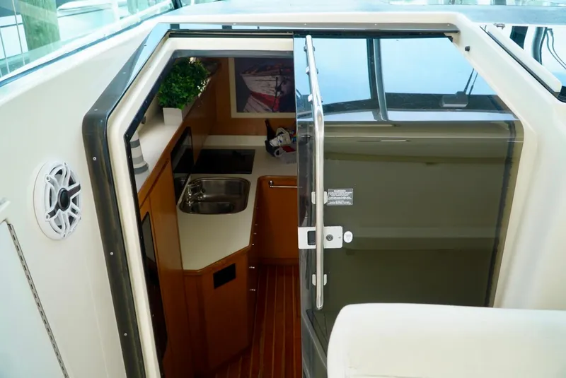 Slide: The Image of 1998 Tiara Yachts 4000 Express interior with kitchenette and seating area. - 17