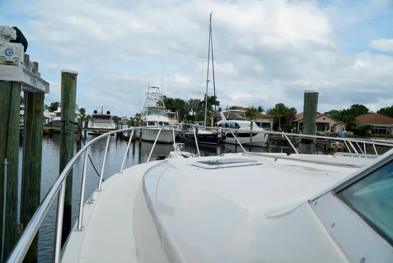 Slide: The Image of 1998 Tiara Yachts 4000 Express docked at a marina under a cloudy sky. - 33