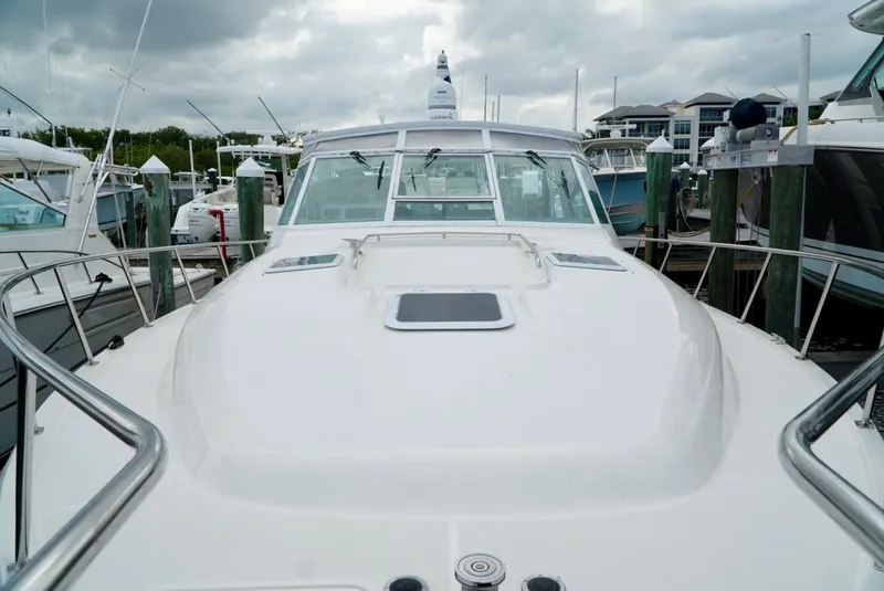 Slide: The Image of 1998 Tiara Yachts 4000 Express docked at marina under cloudy skies. - 34