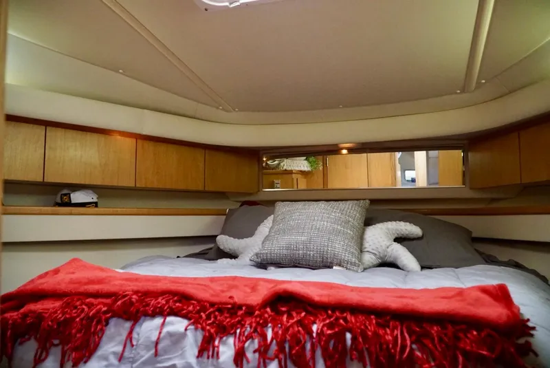 Slide: The Image of Cozy cabin interior of 1998 Tiara Yachts 4000 Express with red blanket and pillows. - 35