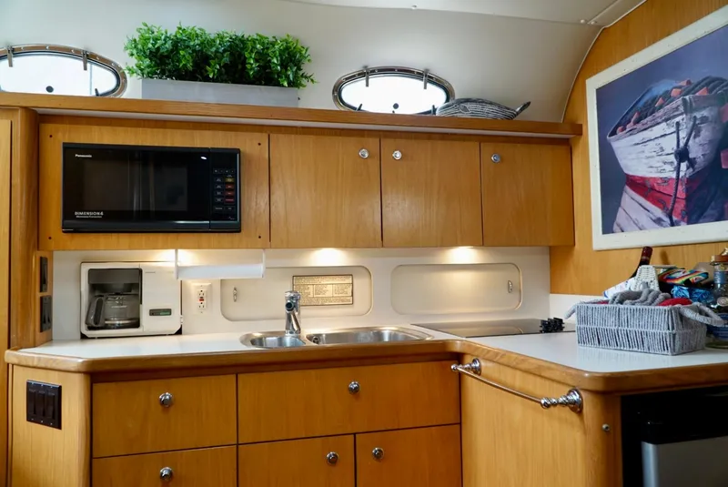 Slide: The Image of 1998 Tiara Yachts 4000 Express kitchen with wooden cabinets, microwave, and sink. - 37