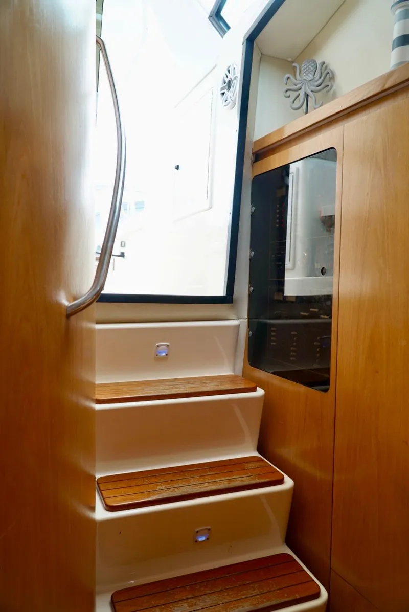 Slide: The Image of Staircase inside 1998 Tiara Yachts 4000 Express, featuring wooden steps and modern design. - 38