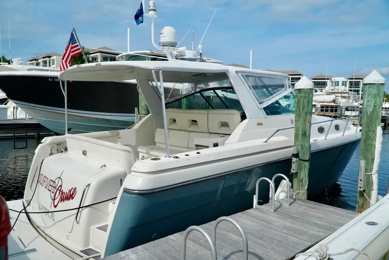 Slide: The Image of 1998 Tiara Yachts 4000 Express docked at marina, featuring sleek design and spacious deck. - 4