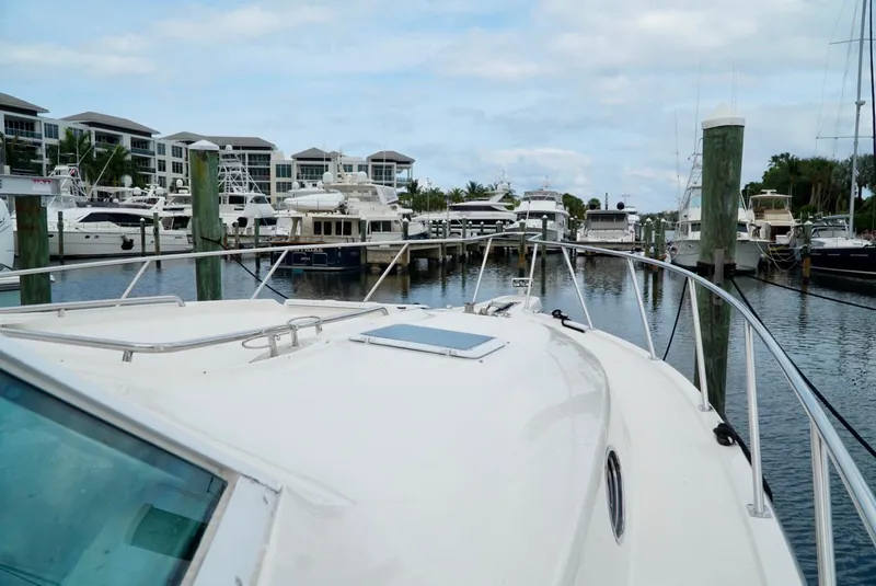 Slide: The Image of 1998 Tiara Yachts 4000 Express docked in a marina with other boats. - 43