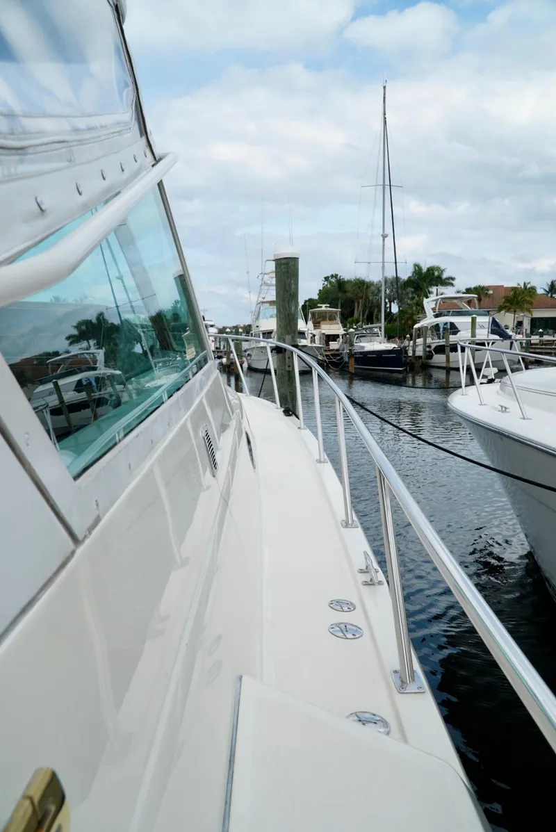 Slide: The Image of 1998 Tiara Yachts 4000 Express docked, showcasing sleek design and marina view. - 49