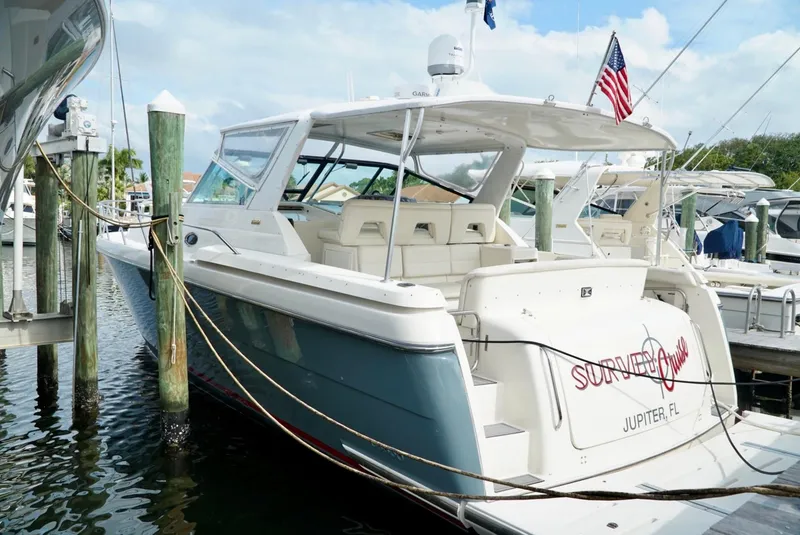 Slide: The Image of 1998 Tiara Yachts 4000 Express docked, featuring sleek design and American flag. - 5