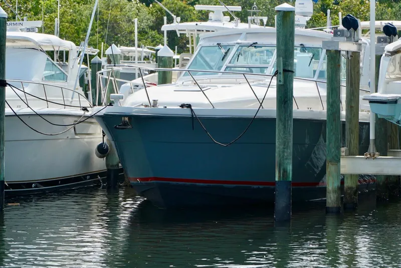 Slide: The Image of 1998 Tiara Yachts 4000 Express docked at marina, surrounded by other boats. - 6