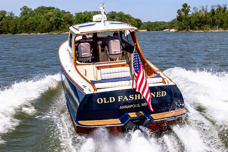 Slide: The Image of 2002 Hinckley Picnic Boat EP cruising on water, displaying American flag, rear view. - 15