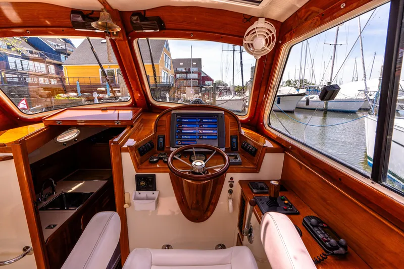 Slide: The Image of 2002 Hinckley Picnic Boat EP interior with wooden dashboard and marina view. - 28