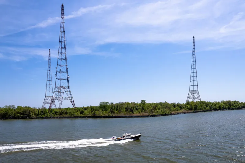 Slide: The Image of A 2002 Hinckley Picnic Boat EP cruising near tall radio towers on a sunny day. - 42
