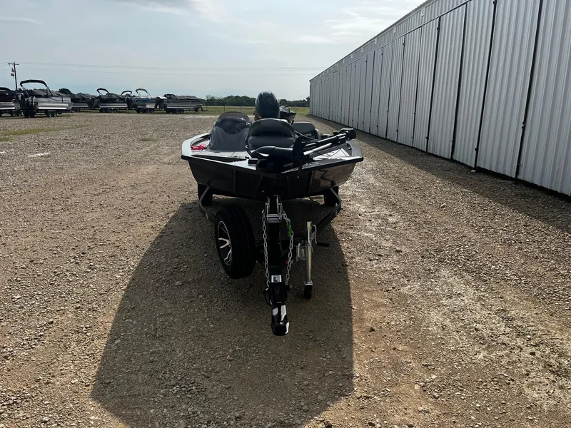 Slide: The Image of 2025 G3 Sportsman 1710 PFX boat on trailer, parked on gravel near storage units. - 2