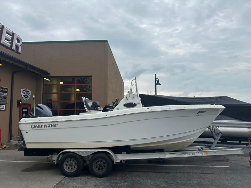 Slide: The Image of 2016 Clearwater 2200CC boat on trailer outside a building under cloudy sky. - 1