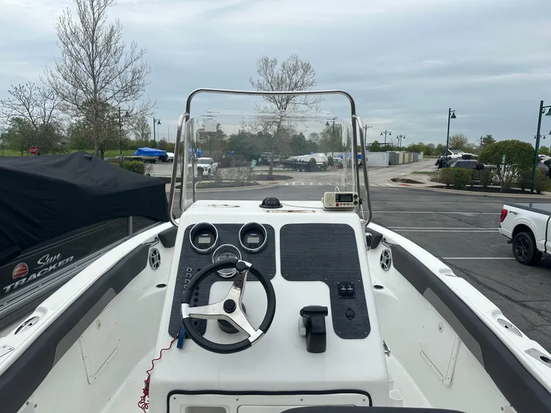 Slide: The Image of Clearwater 2200CC 2016 boat dashboard with steering wheel and controls in a parking lot. - 5