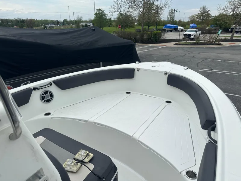Slide: The Image of 2016 Clearwater 2200CC boat interior with seating and speaker, parked outdoors. - 6