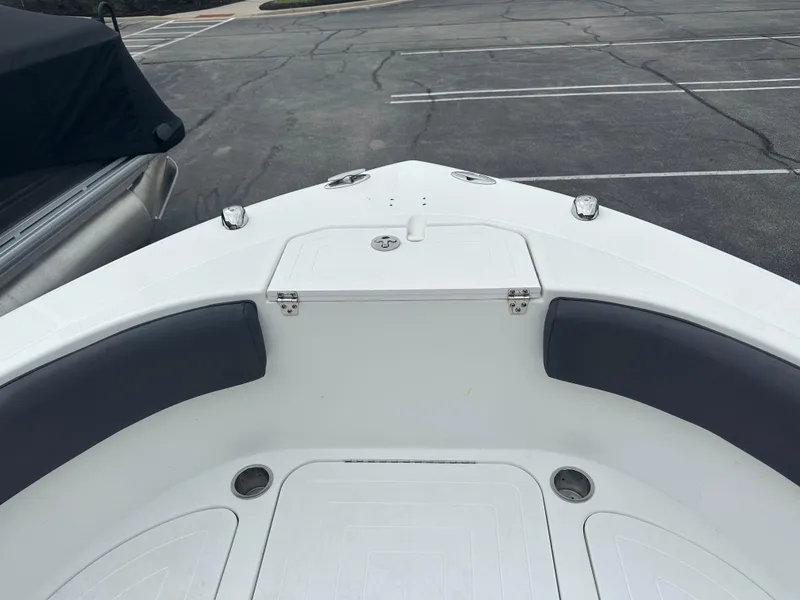 Slide: The Image of 2016 Clearwater 2200CC boat bow with seating and storage in a parking lot. - 7