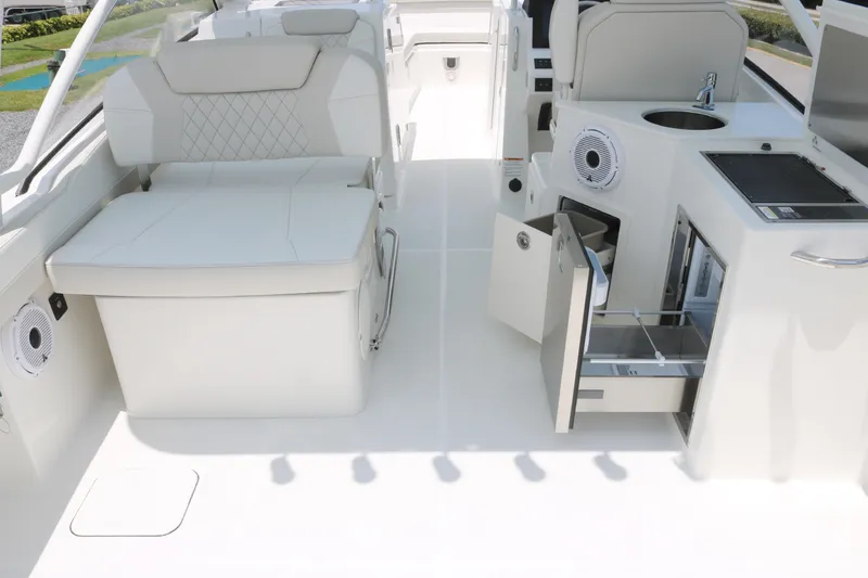 Slide: The Image of 2025 World Cat 280 DC boat interior with seating, storage, and kitchenette. - 12