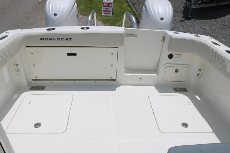 Slide: The Image of 2025 World Cat 280 DC boat deck with storage compartments and twin engines. - 13