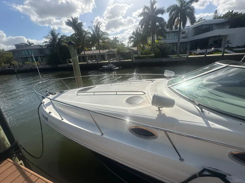 Slide: The Image of 2008 Sea Ray 420 Sundancer docked by waterfront homes, under a partly cloudy sky. - 10