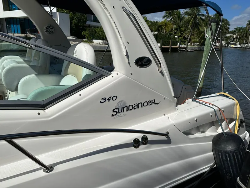 Slide: The Image of 2008 Sea Ray 340 Sundancer boat docked by the water, featuring sleek design and comfortable seating. - 13