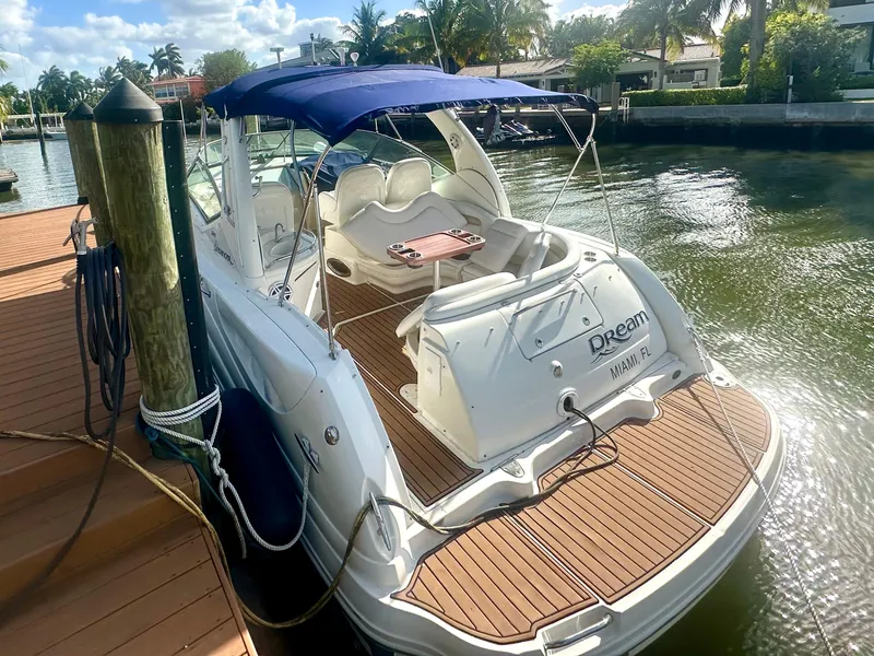 Slide: The Image of 2008 Sea Ray 420 Sundancer docked, featuring a spacious deck and blue canopy. - 14