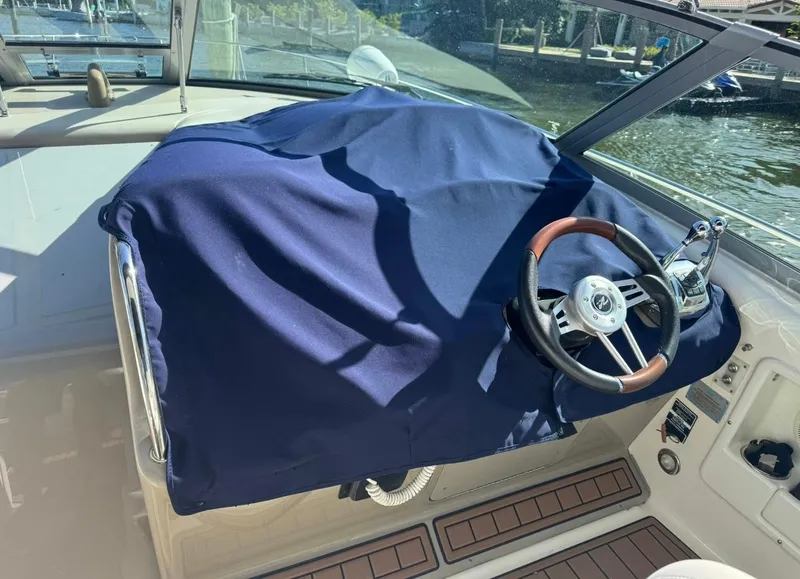 Slide: The Image of 2008 Sea Ray 340 Sundancer helm with blue cover and wooden steering wheel. - 24