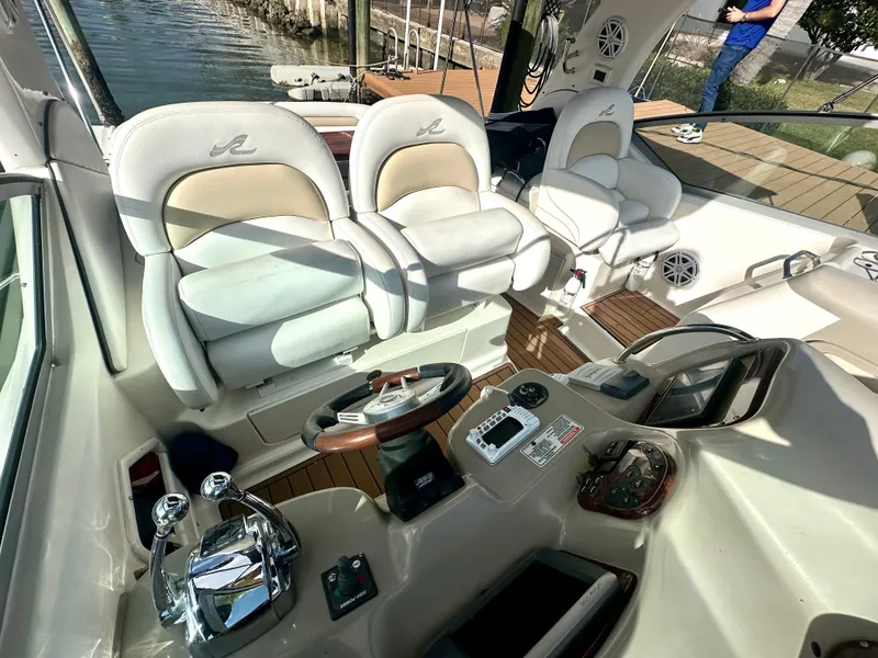Slide: The Image of 2008 Sea Ray 420 Sundancer cockpit with helm, controls, and seating by the water. - 31