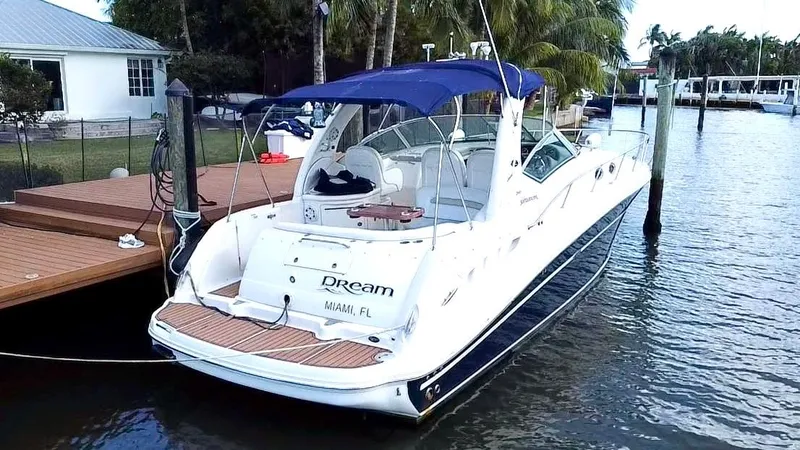 Slide: The Image of 2008 Sea Ray 420 Sundancer docked, featuring sleek design and blue canopy. - 4