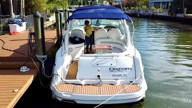 Slide: The Image of 2008 Sea Ray 420 Sundancer docked in Miami, featuring a blue canopy and wooden deck. - 7