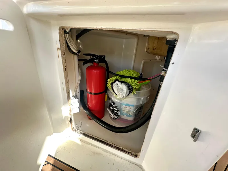 Slide: The Image of Storage compartment on a 2008 Sea Ray 420 Sundancer with fire extinguisher and cleaning supplies. - 81