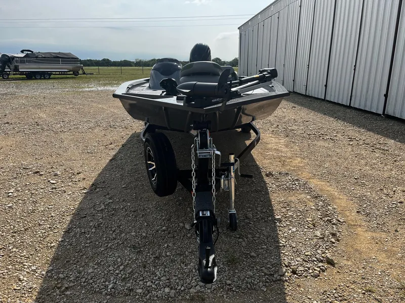 Slide: The Image of 2025 G3 Sportsman 1810 PFX boat on trailer, parked on gravel near storage facility. - 2