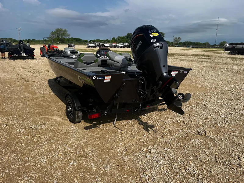 Slide: The Image of 2025 G3 Sportsman 1810 PFX boat on gravel lot, rear view with motor. - 5