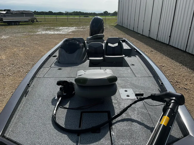 Slide: The Image of 2025 G3 Sportsman 1810 PFX fishing boat with seating and motor, parked outdoors. - 7