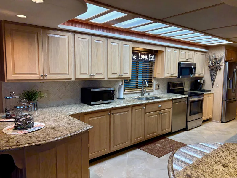 Slide: The Image of Spacious kitchen in 2000 Stardust Cruisers 18x83 houseboat with modern appliances and wooden cabinetry. - 3