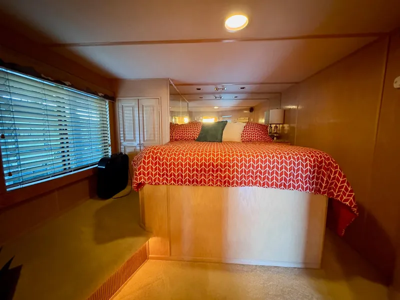 Slide: The Image of Cozy bedroom in 2000 Stardust Cruisers 18x83 houseboat with red bedding and ambient lighting. - 5