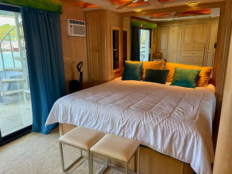 Slide: The Image of Luxurious bedroom in 2000 Stardust Cruisers 18x83 houseboat with elegant decor and waterfront view. - 9