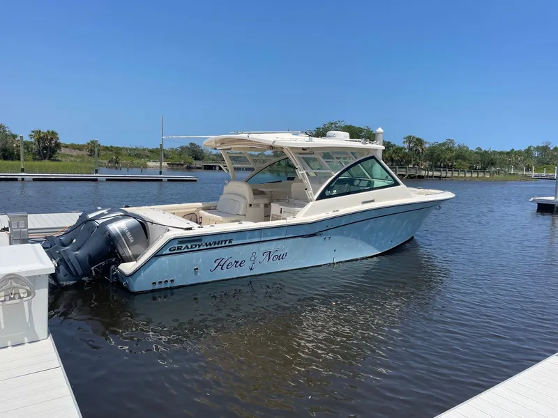 Slide: The Image of 2018 Grady-White Freedom 375 boat docked on calm water under clear blue sky. - 1