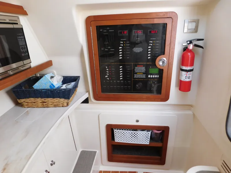 Slide: The Image of Electrical panel and storage area inside a 2018 Grady-White Freedom 375 boat cabin. - 12