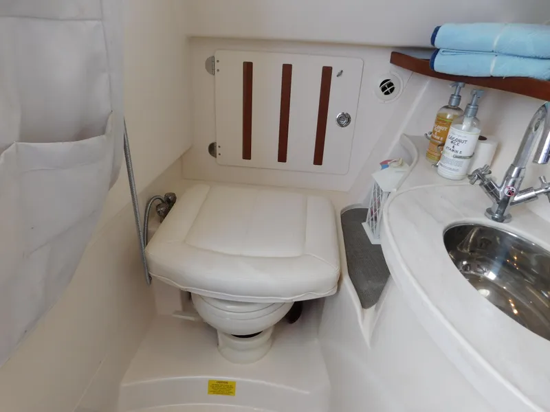 Slide: The Image of 2018 Grady-White Freedom 375 boat bathroom with toilet, sink, and toiletries. - 13