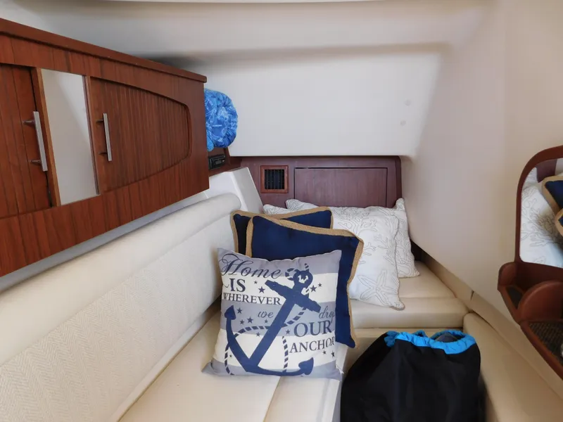 Slide: The Image of 2018 Grady-White Freedom 375 cabin interior with nautical-themed pillows and wooden cabinetry. - 19