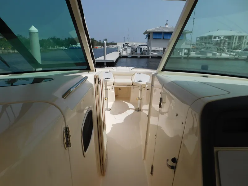 Slide: The Image of 2018 Grady-White Freedom 375 boat interior at marina, showcasing helm and seating area. - 24