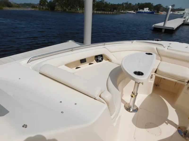 Slide: The Image of 2018 Grady-White Freedom 375 boat interior with seating and table, docked by the water. - 25