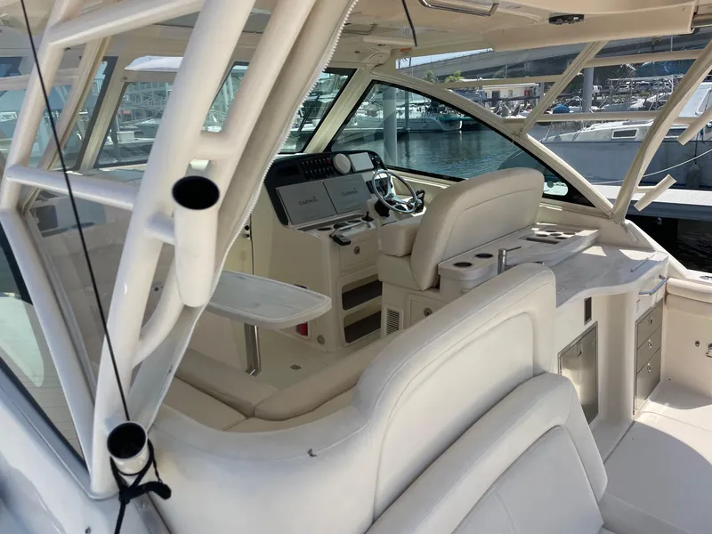 Slide: The Image of 2018 Grady-White Freedom 375 boat interior with helm, seating, and marina view. - 6
