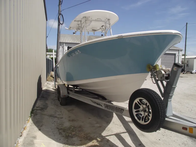 Slide: The Image of 2016 Sportsman Open 232 Center Console boat on trailer, parked outdoors. - 2