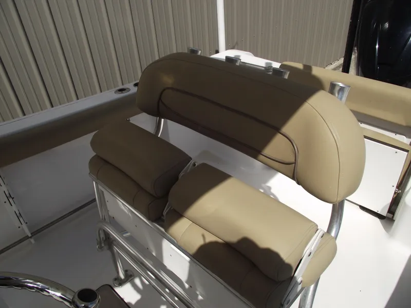 Slide: The Image of 2016 Sportsman Open 232 Center Console boat seating with tan cushions and metal frame. - 23