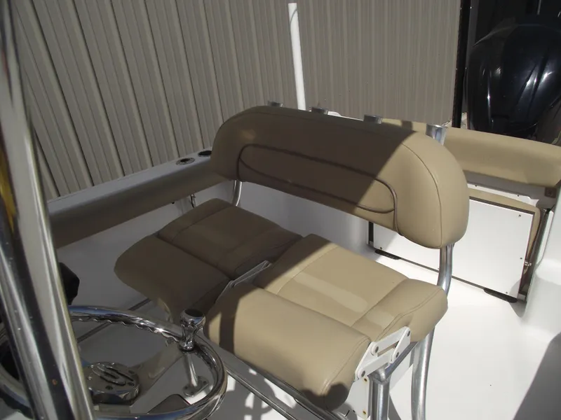 Slide: The Image of 2016 Sportsman Open 232 Center Console boat with beige seating and steering wheel. - 24