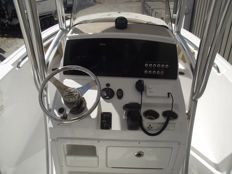 Slide: The Image of 2016 Sportsman Open 232 Center Console boat dashboard with steering wheel and controls. - 26