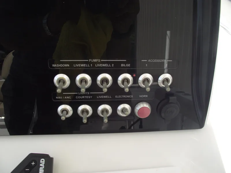 Slide: The Image of Control panel of a 2016 Sportsman Open 232 Center Console boat with labeled switches. - 28
