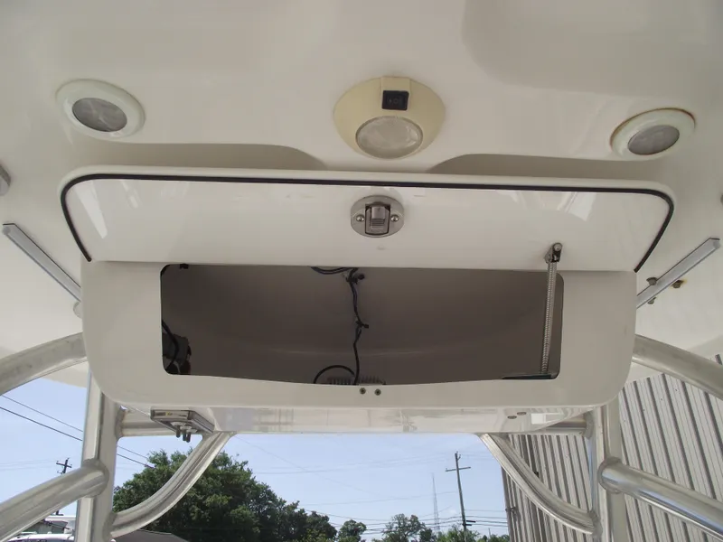 Slide: The Image of 2016 Sportsman Open 232 Center Console storage compartment with open hatch and visible wiring. - 33
